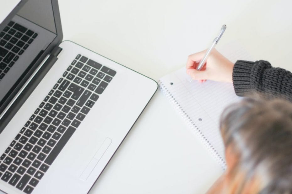 Person with a laptop making notes
